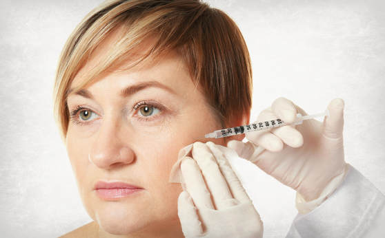 Middle aged woman getting a filler injection in a cheekbone